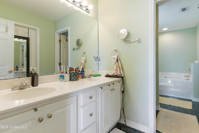 bathroom featuring double vanity, a bath, visible vents, a sink, and tile patterned floors