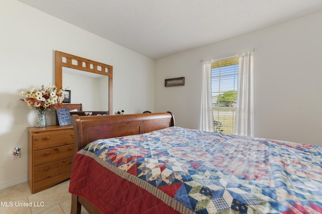 bedroom with baseboards and light tile patterned floors