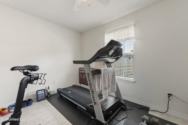 workout room with baseboards, a textured ceiling, ceiling fan, and tile patterned floors