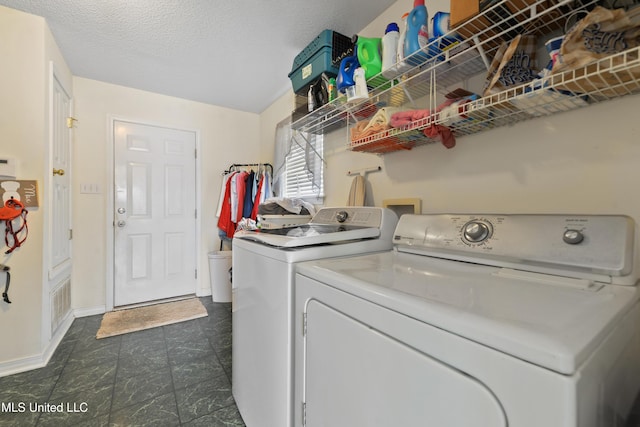 clothes washing area with washing machine and clothes dryer, laundry area, and baseboards