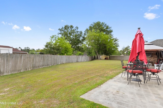 view of yard featuring a gazebo, a fenced backyard, outdoor dining space, and a patio