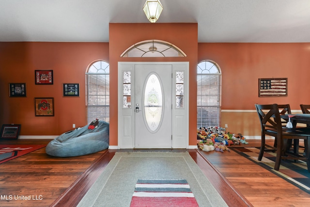 foyer featuring baseboards and wood finished floors