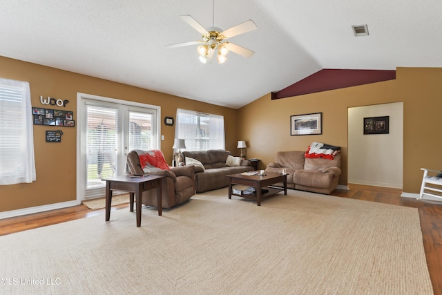 living room with baseboards, ceiling fan, wood finished floors, and vaulted ceiling