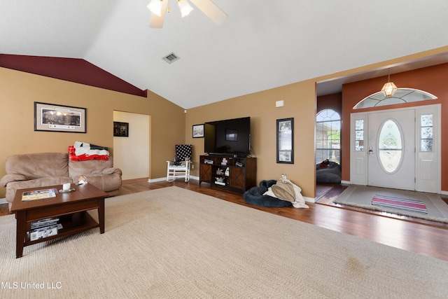 living area featuring ceiling fan, visible vents, wood finished floors, baseboards, and lofted ceiling