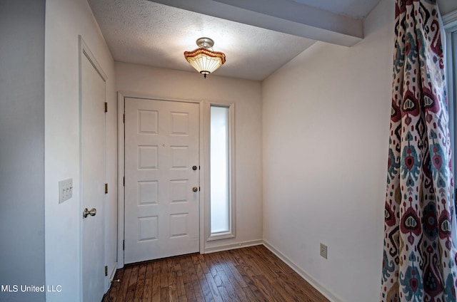 foyer entrance with dark hardwood / wood-style floors, beamed ceiling, and a textured ceiling