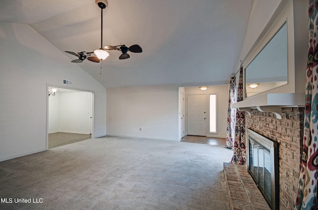 unfurnished living room featuring a brick fireplace, carpet floors, high vaulted ceiling, and ceiling fan