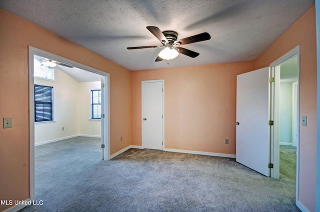 carpeted empty room featuring a textured ceiling and ceiling fan