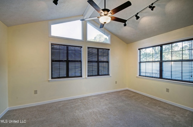 empty room featuring light carpet, track lighting, ceiling fan, a textured ceiling, and vaulted ceiling