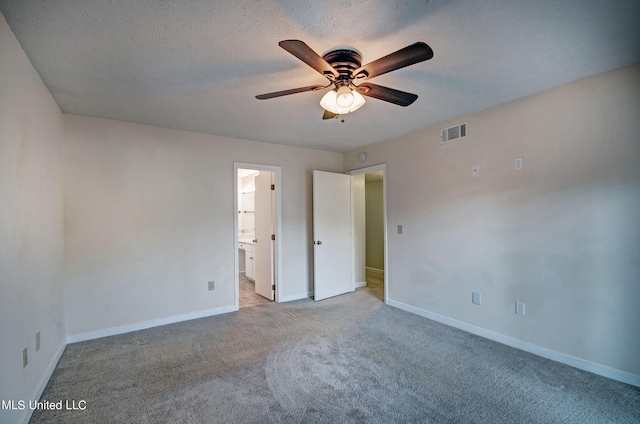 unfurnished bedroom with light carpet, a textured ceiling, ensuite bath, and ceiling fan