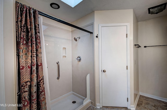 bathroom featuring a skylight, a textured ceiling, and walk in shower