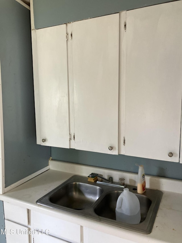 1710 Eastward Dr, Gulfport, MS 39501 - kitchen view of a sink, white cabinets, and light countertops