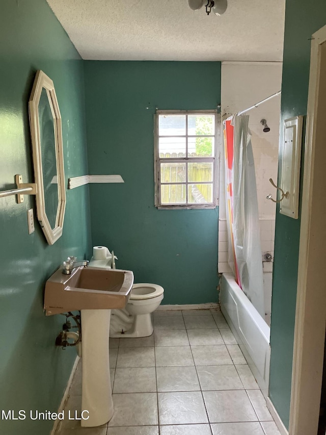 1710 Eastward Dr, Gulfport, MS 39501 - full bathroom featuring toilet, a textured ceiling, tile patterned floors, baseboards, and shower / tub combo with curtain