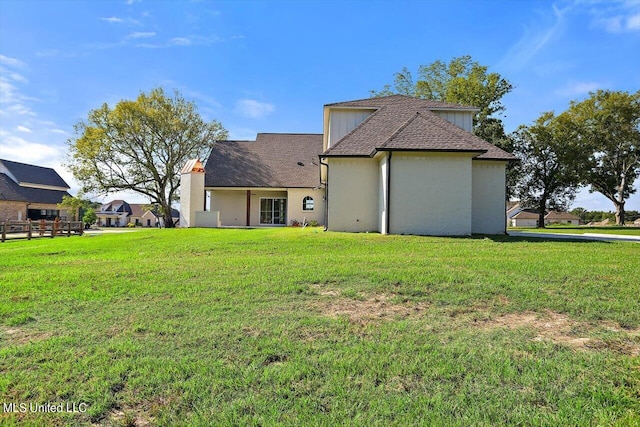 rear view of property with a yard