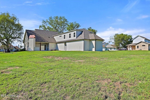 rear view of property featuring a lawn