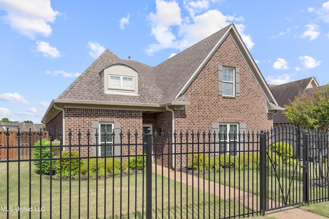 view of front of home featuring brick siding and roof with shingles