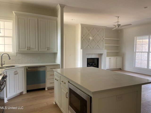 422 Baleigh Way, Canton, MS 39046 - kitchen featuring stainless steel appliances, a sink, light wood-style flooring, ornamental molding, and a ceiling fan