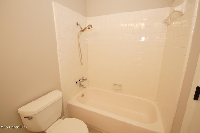 bathroom with tiled shower / bath combo and toilet