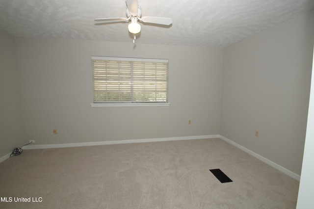 carpeted spare room with a textured ceiling and ceiling fan