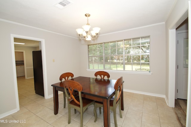 tiled dining room featuring ornamental molding and an inviting chandelier