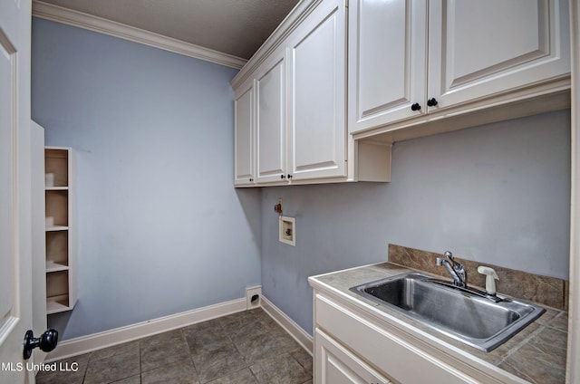 laundry room featuring hookup for a washing machine, sink, a textured ceiling, crown molding, and cabinets