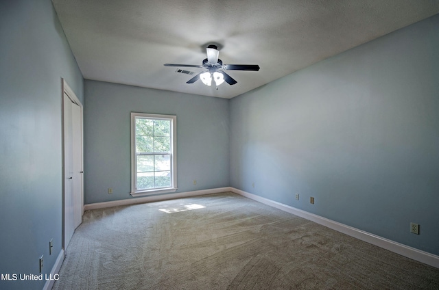 spare room featuring light carpet, a textured ceiling, and ceiling fan