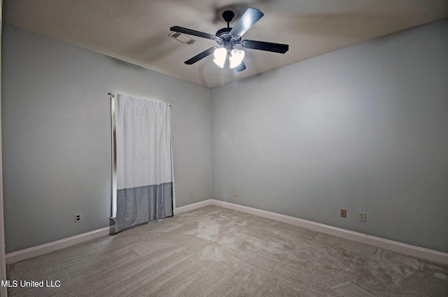 spare room featuring a textured ceiling, light colored carpet, and ceiling fan