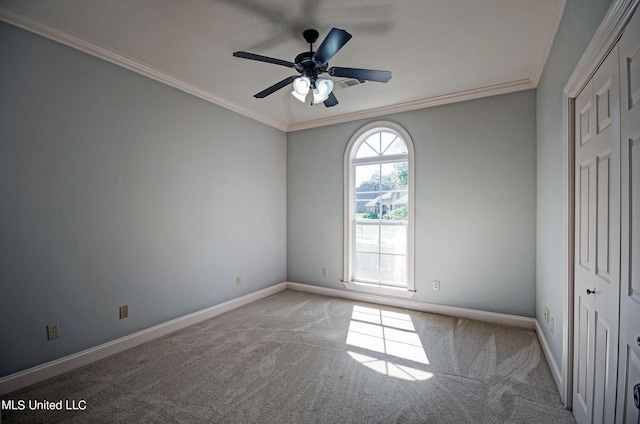 carpeted spare room featuring ornamental molding and ceiling fan