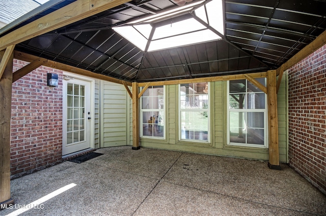 unfurnished sunroom featuring vaulted ceiling