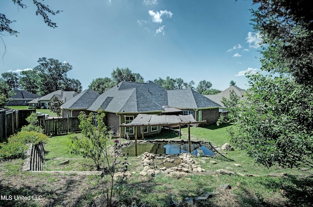 rear view of house with a yard