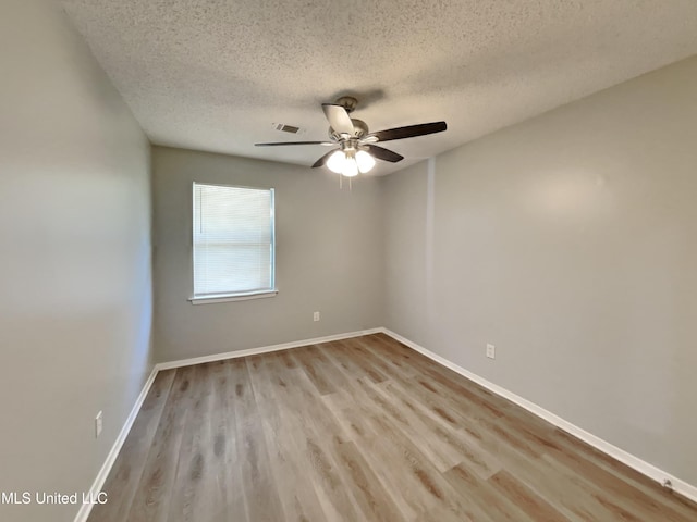 6525 Yorkshire Rd, Horn Lake, MS 38637 - spare room with a textured ceiling, wood finished floors, ceiling fan, and baseboards