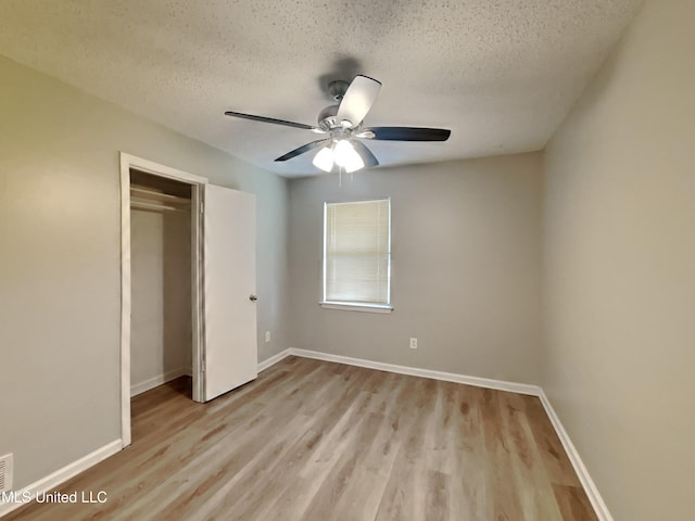 6525 Yorkshire Rd, Horn Lake, MS 38637 - unfurnished bedroom with light wood-style flooring, a textured ceiling, a closet, baseboards, and a ceiling fan