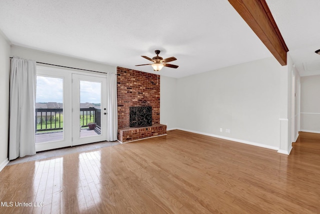 8279 Dunn Ln, Olive Branch, MS 38654 - unfurnished living room featuring a ceiling fan, wood finished floors, a fireplace, and beam ceiling