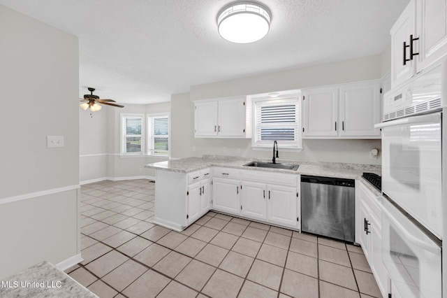 8279 Dunn Ln, Olive Branch, MS 38654 - kitchen featuring stainless steel dishwasher, a peninsula, light countertops, light tile patterned floors, and white cabinets