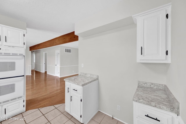 8279 Dunn Ln, Olive Branch, MS 38654 - kitchen featuring double oven, light countertops, white cabinetry, and light tile patterned floors