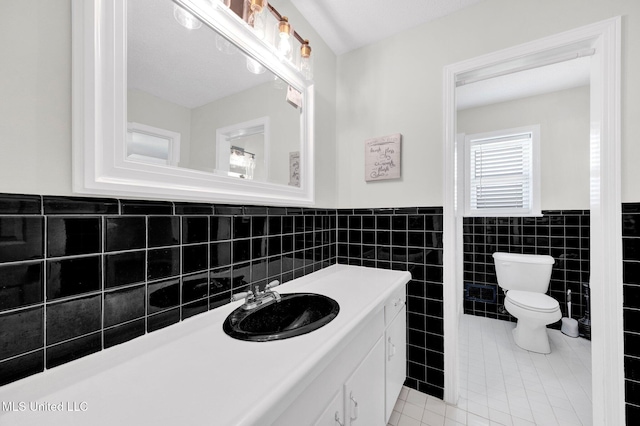 8279 Dunn Ln, Olive Branch, MS 38654 - bathroom featuring tile walls, vanity, tile patterned flooring, and wainscoting
