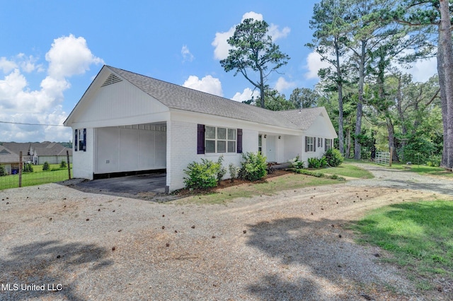 8279 Dunn Ln, Olive Branch, MS 38654 - ranch-style house with brick siding, dirt driveway, an attached carport, and a shingled roof