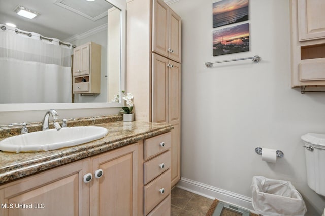 bathroom featuring crown molding, toilet, vanity, tile patterned flooring, and baseboards