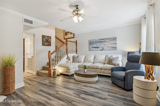 living area featuring stairway, visible vents, wood finished floors, and ornamental molding