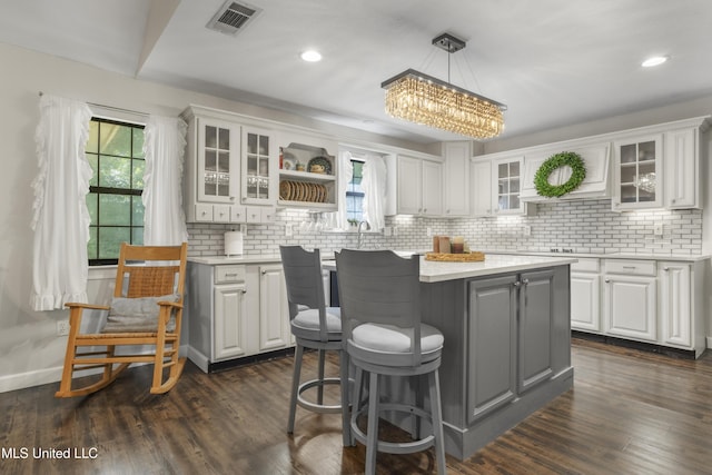 kitchen featuring light countertops, a center island, a wealth of natural light, and visible vents