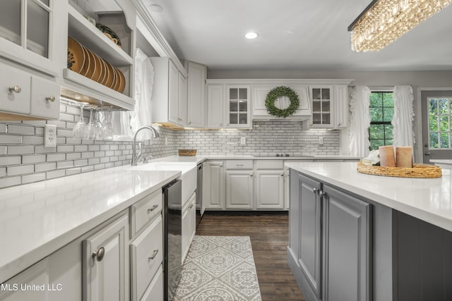 kitchen featuring light countertops, white cabinets, black electric stovetop, and a sink