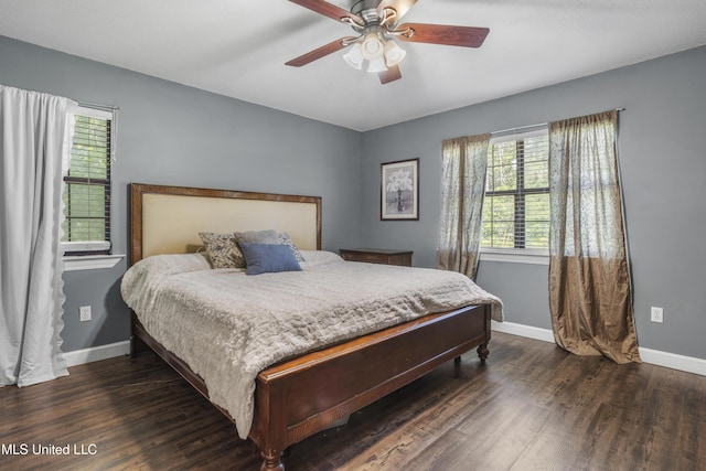 bedroom with baseboards, wood finished floors, and multiple windows