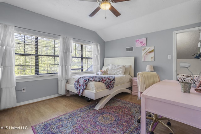bedroom featuring visible vents, baseboards, wood finished floors, and vaulted ceiling