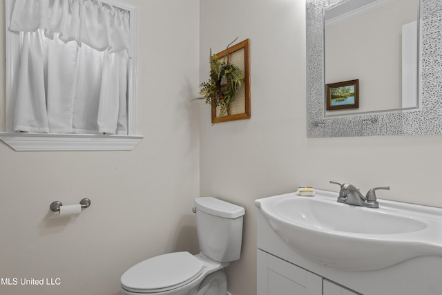 bathroom with crown molding, vanity, and toilet
