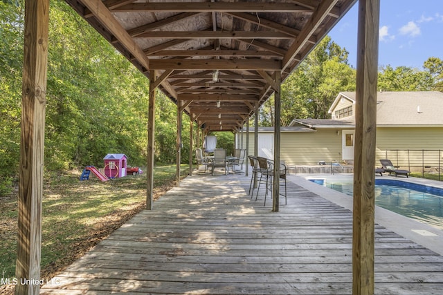 wooden deck featuring an outdoor pool and fence