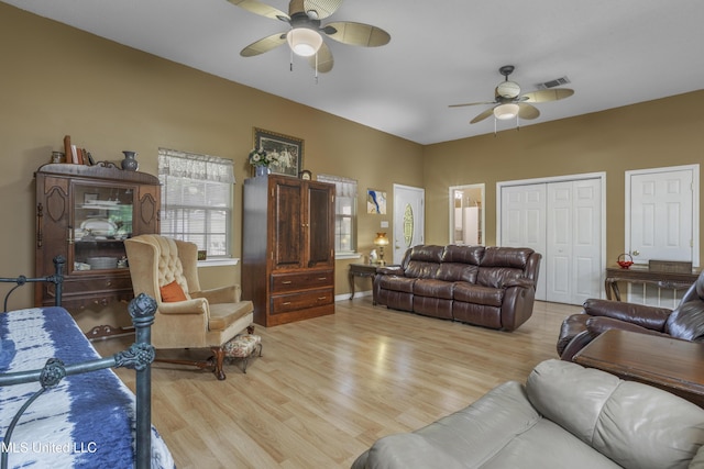 living room featuring a ceiling fan, visible vents, and wood finished floors