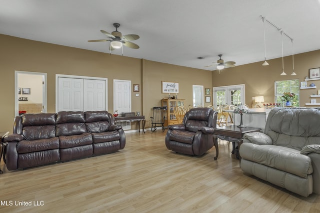 living area with rail lighting, light wood finished floors, and ceiling fan