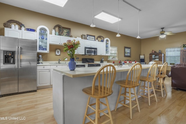 kitchen with light wood-type flooring, light countertops, and appliances with stainless steel finishes