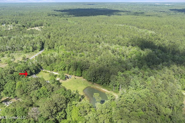 drone / aerial view featuring a wooded view