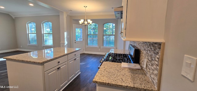 kitchen featuring a center island, dark hardwood / wood-style flooring, pendant lighting, stainless steel range, and white cabinets