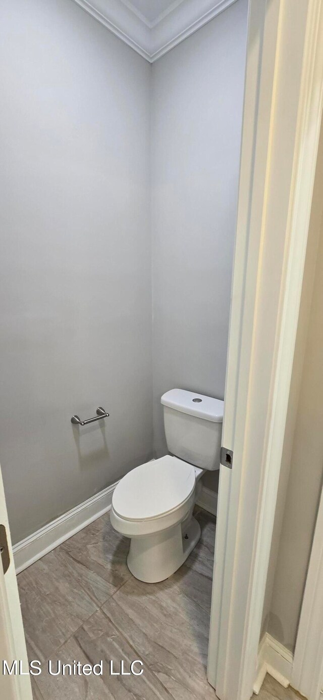 bathroom with crown molding, wood-type flooring, and toilet